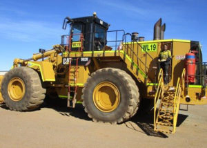 young adult male jobseeker in PPE stands on mining truck