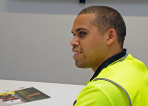 indigenous man at an office desk in high vis