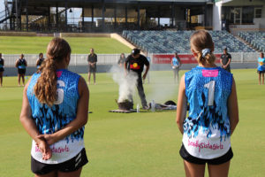 deadly sista girlz students watching an aboriginal smoking ceremony on a cricket ground